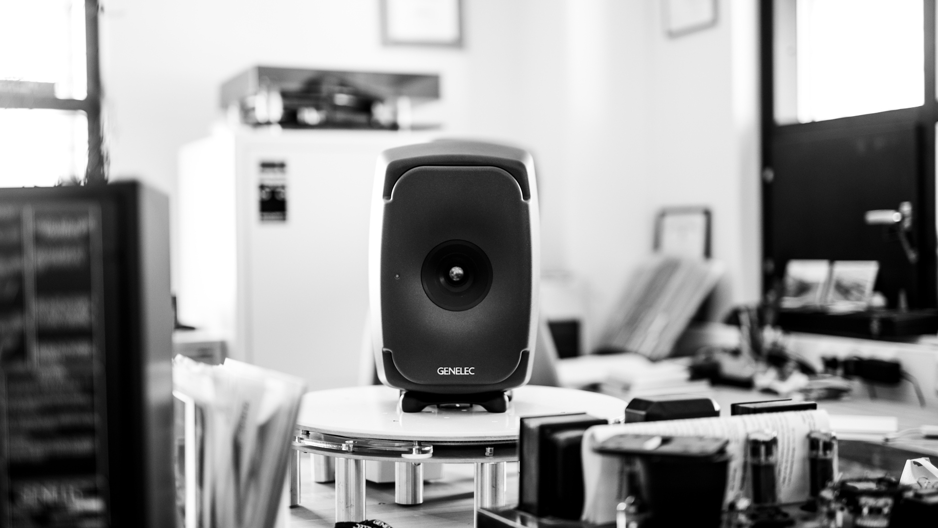 Genelec studio monitor in a minimalist office-style listening environment